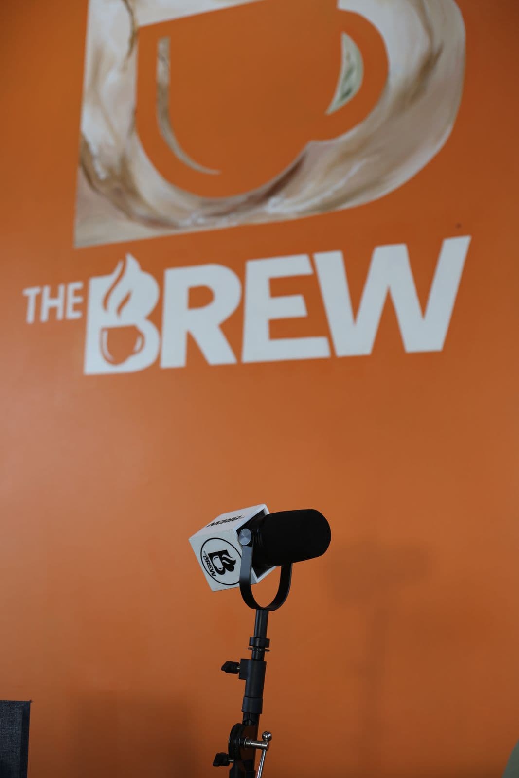 A Brew-branded microphone against the orange wall